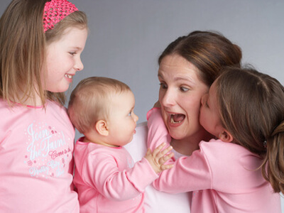 Bei der Kinderbetreuung spielt eine Tagesmutter mit drei Geschwistern.